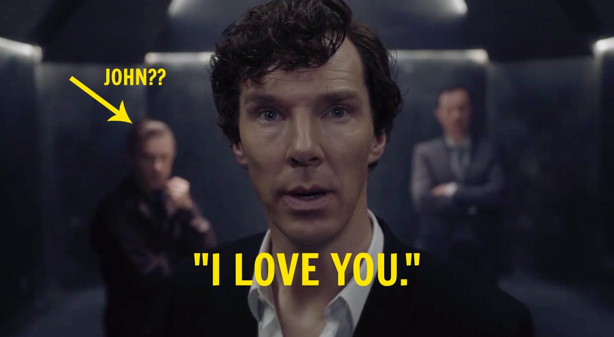 Color screenshot from series 4 trailer of Holmes in an oddly lit black room, with two out-of-focus men behind him, discernible as Watson to the left, Moriarty to the right. Yellow arrow points to Watson with text 'JOHN??' Yellow all-caps words under Holmes read 'I LOVE YOU.'