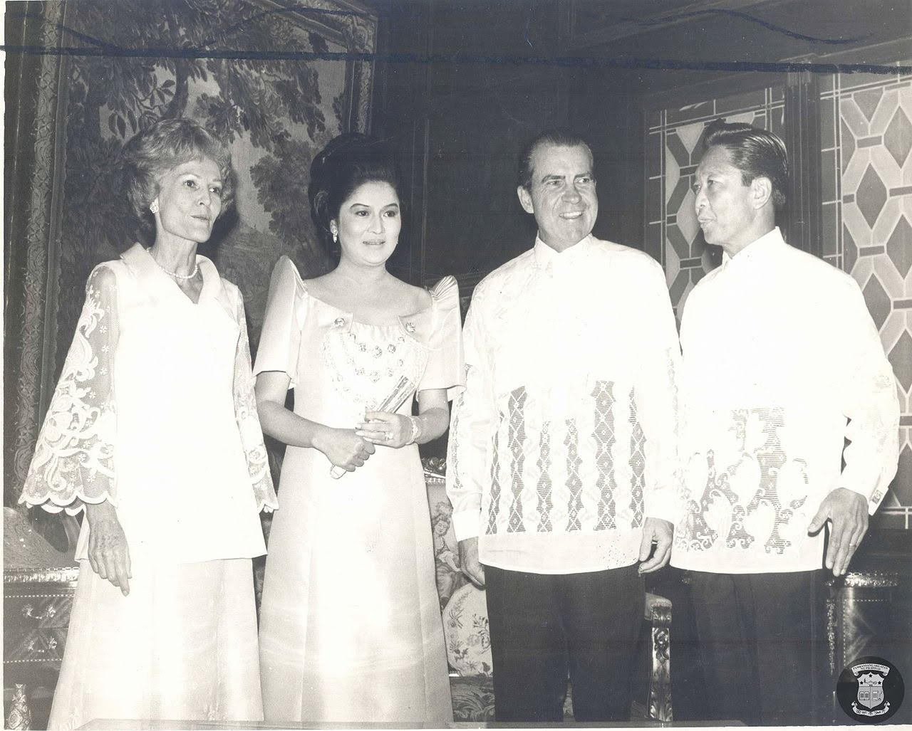 Black-and-white photograph of Richard and Pat Nixon and Ferdinand and Imelda Marcos, the men wearing traditional Filipino dress shirts and the women wearing traditional Filipino formal gowns.