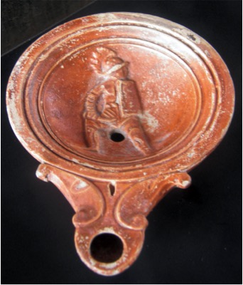 reddish oil lamp, circular with handle, figurine in center