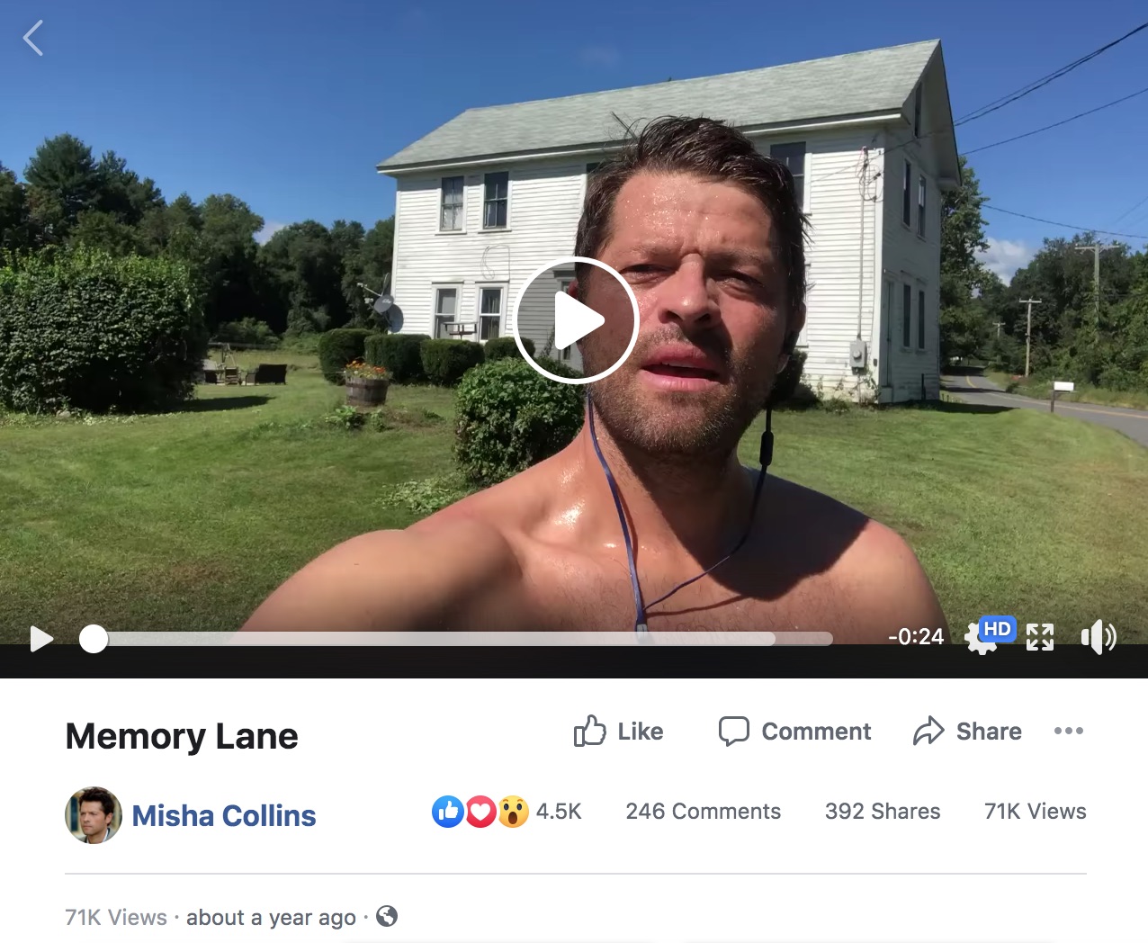 Color screenshot of a livestream video posted to Facebook by Misha Collins from account officialmisha dated September 18, 2018. Still frame shows Misha Collins, shirtless and wearing earbuds, standing in the yard behind a three-story white house by a small road.