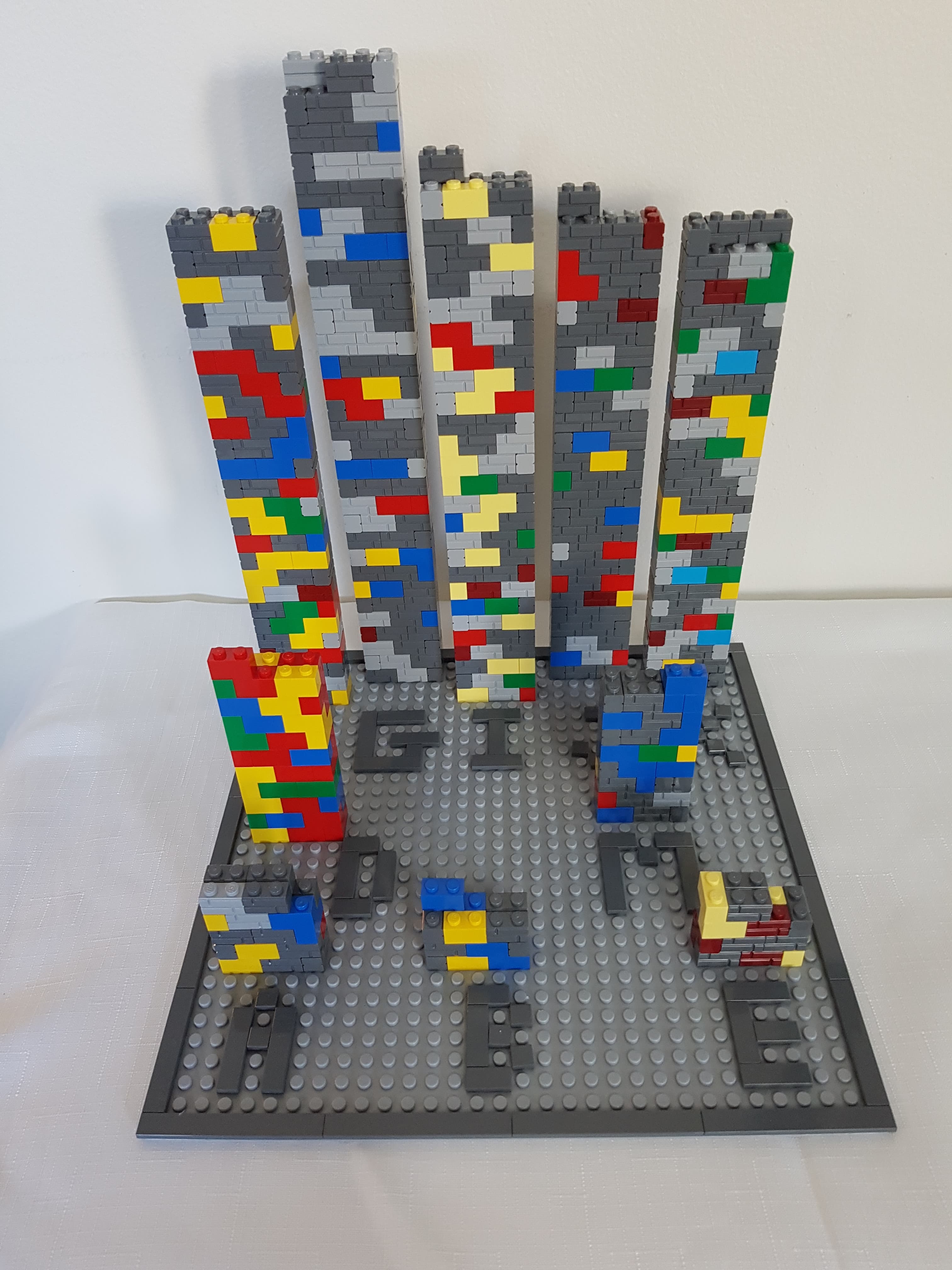Image of ten towers of varying sizes made from multicolored Lego bricks. Each tower is labeled with a letter that refers to the participant's code name.