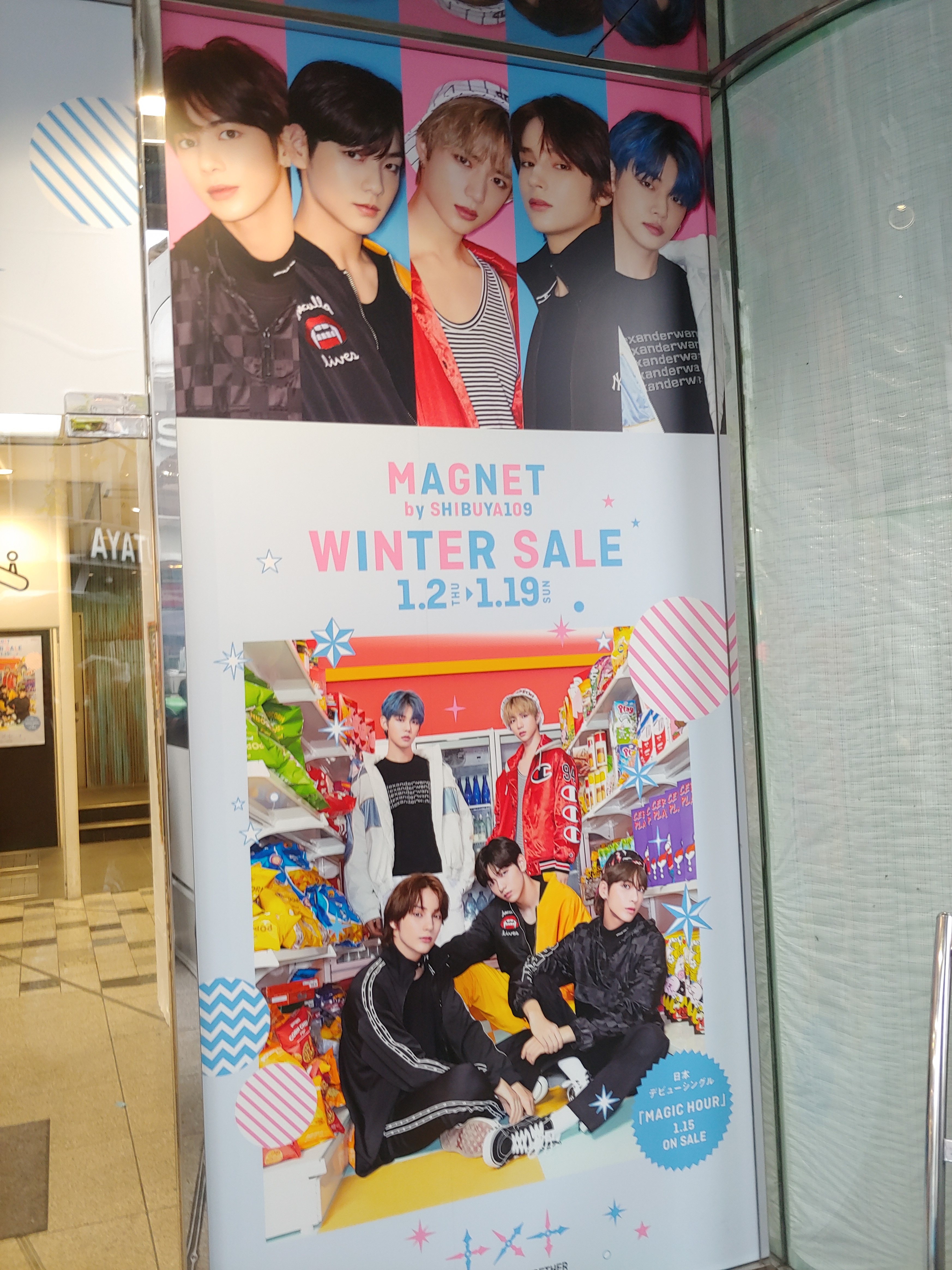A poster featuring the headshots of 5 K-Pop band members above the words Magnet by Shibuya109 Winter Sale, 1.2 Thu to 1.19 Sun. Below this is a group shot of the band posing together.