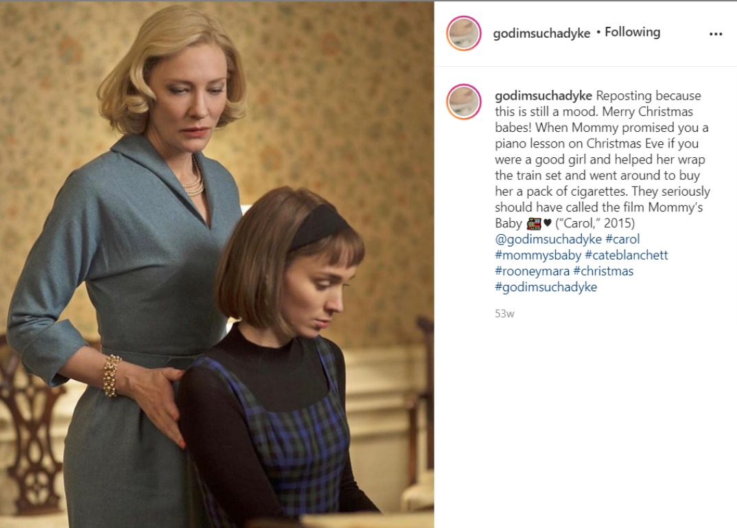 Screenshot of an instagram post by godimsuchadyke showing Therese seated and Carol stood behind her, touching her shoulder.