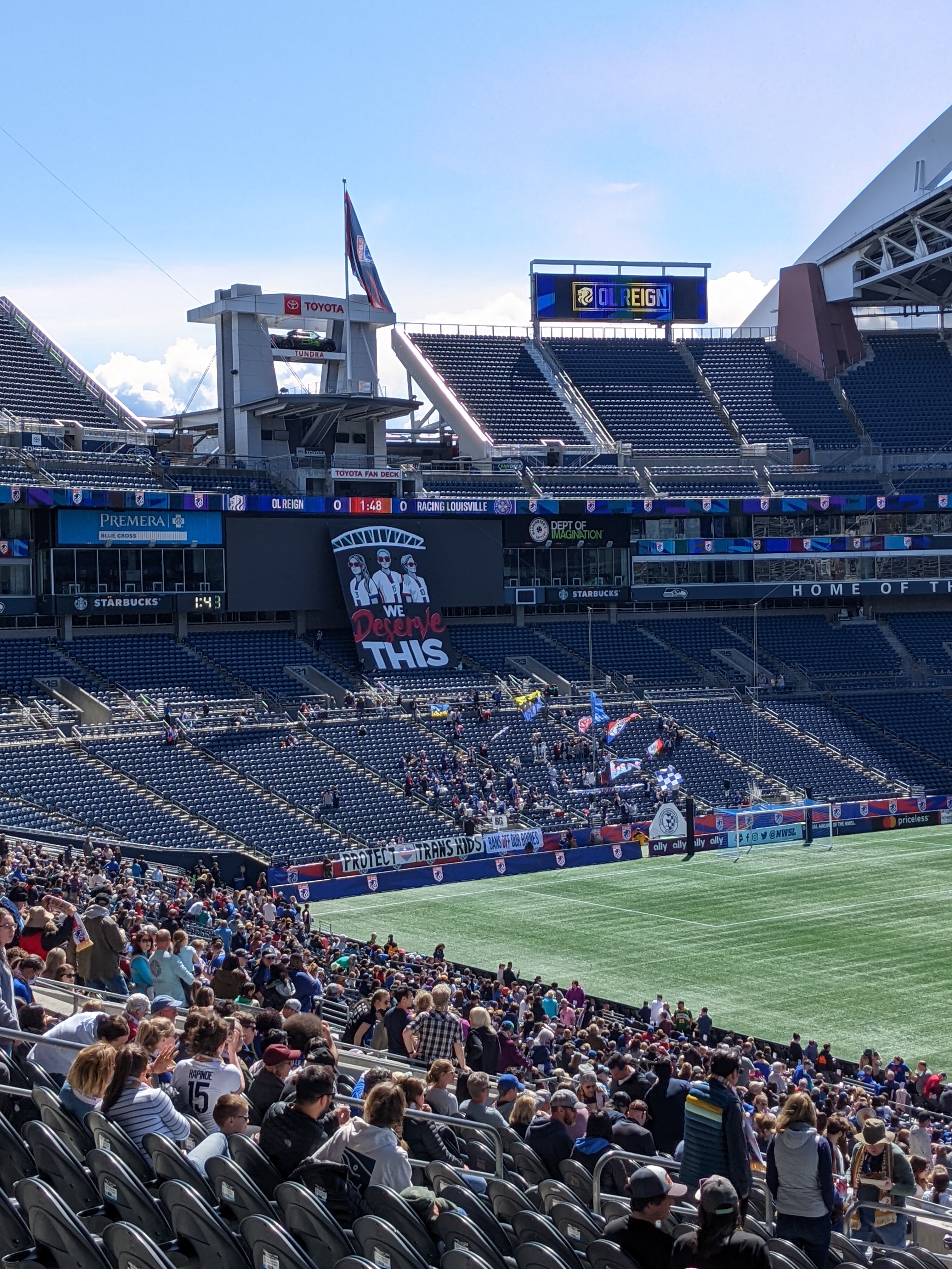 Fans display tifo with art of the three players wearing sunglasses and the text 'We deserve this.'