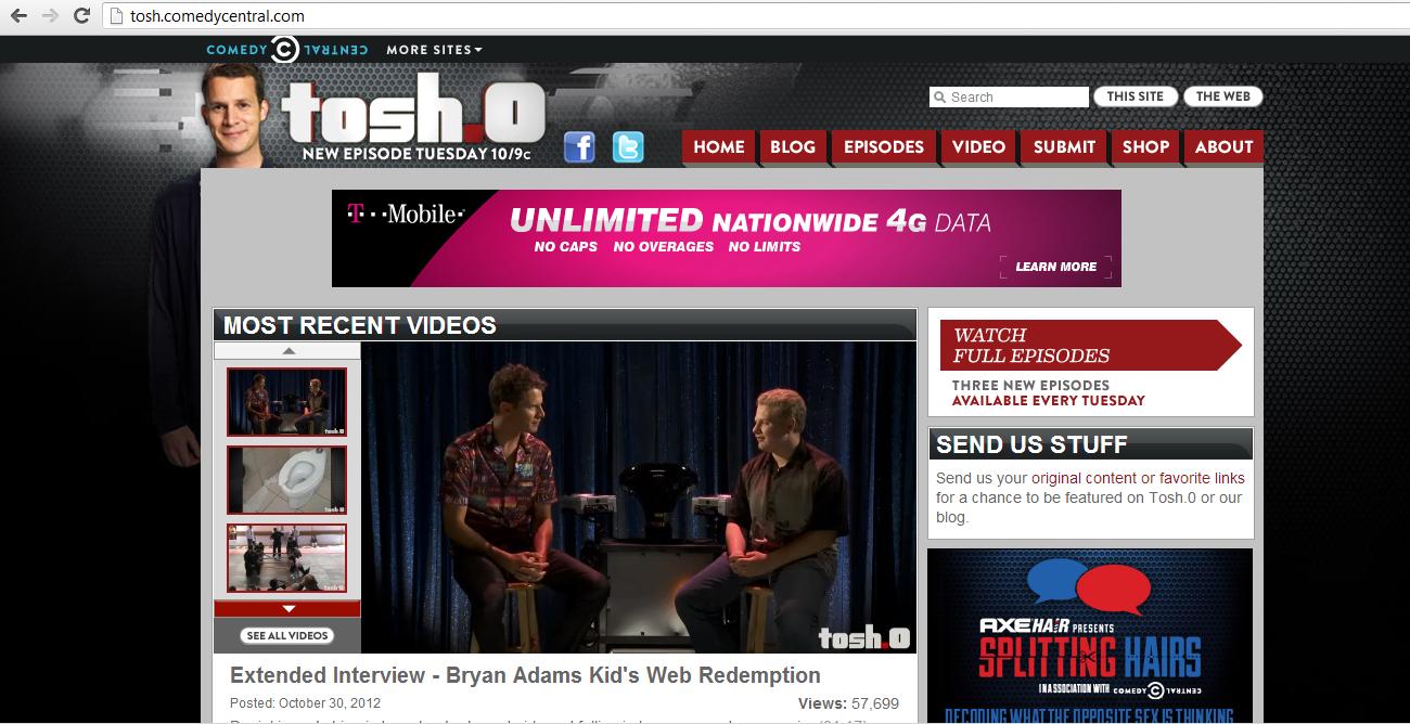 The Tosh.0 home page, as described in the preceding paragraph and also containing a still image of two men on stools facing one another under the heading 'Most Recent Videos' with the caption 'Extended Interview - Bryan Adams Kid's Web Redemption, Posted October 30, 2012, Views: 57,699'. Beneath the header menu and above the Most Recent Videos is an an for T-Mobile reading 'Unlimited Nationwide 4G Data, No Caps, No Overages, No Limits. Learn More.' A sidebar to the right of the Most Recent Videos contains three visible items: 'Watch Full Episodes: Three New Episodes Available Every Tuesday'; 'Send Us Stuff: Send us your original content or favorite links for a chance to be featured on Tosh.0 or our blog'; and a partial advertisement reading 'AxeHair presents Splitting Hairs in association with Comedy Central. Decoding What The Opposite Sex is Thinking.'